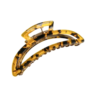 Classic tortoiseshell hair claw clip with acetate finish and metal spring on white background