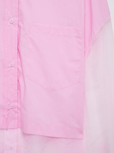 Dettaglio della camicia rosa con patchwork in organza e tasca frontale applicata