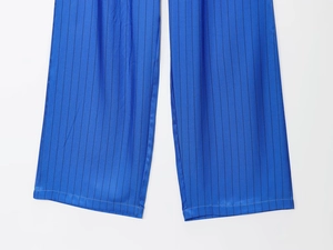 Detailed view of blue striped wide-leg trousers with smooth satin texture and precise stitching
