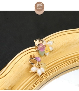Detail of vintage gold plated earrings with colorful gemstones and white natural pearls