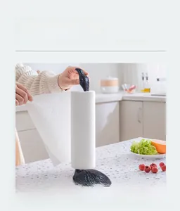 Close-up of hand tearing paper from a black cast iron flamingo kitchen towel holder