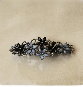 Macro detail of retro alloy hair clip featuring grey-blue crystals and floral pattern