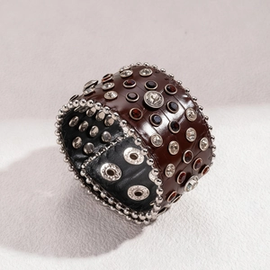 Gros plan d'un bracelet en cuir marron rétro avec strass et détails de clous argentés