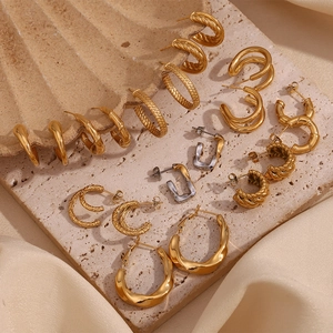 Détail de boucles d'oreilles doubles en forme de C, finitions dorées et argentées
