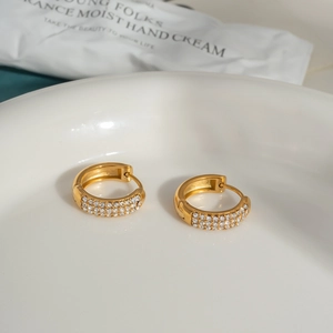 Detailed close-up of 18K gold-plated C-shaped earrings with micro-pave cubic zirconia crystals