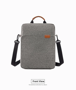 Front view of grey oxford fabric laptop bag with brown leather handles and black shoulder strap