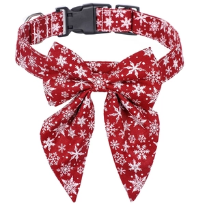 Detail of red Christmas dog collar with white snowflake patterns and metal D-ring