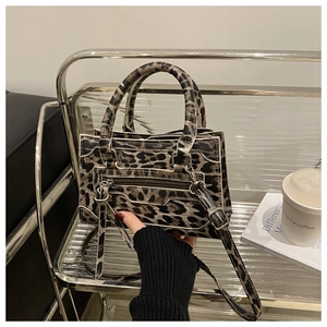 Dettaglio della borsa leopardata con manico rinforzato e particolare della zip in metallo