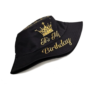 Detail of black cotton bucket hat featuring gold crown print and Birthday text