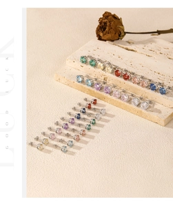Détail macro de clous d'oreilles multicolores en argent s925 avec serti à quatre griffes