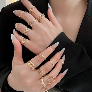 Close-up of a diverse set of gold starfish-themed rings worn by a model in a black suit