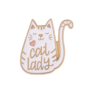Close-up of white enamel cat brooch with gold Cat Lady lettering and pink heart detail