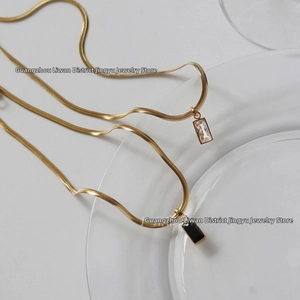 Vue détaillée des chaînes serpent plaquées or 18 carats avec pendentif zircon et onyx noir