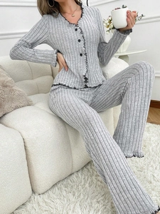 Detail of grey ribbed pajama set featuring black ruffled trim and button-down cardigan