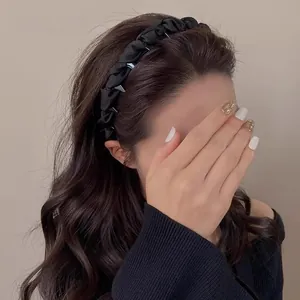 Elegant black pleated headband for women shown on deep brown long curly hair