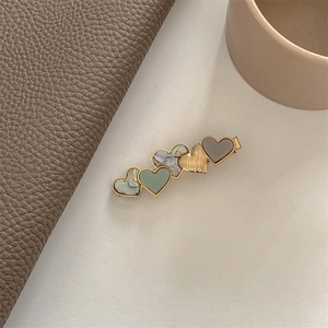 Close-up of heart-shaped acetate hair clip with morandi green and marble patterns