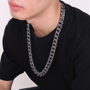 Gros plan d'un collier cubain épais en acier inoxydable avec crâne pour homme sur mannequin