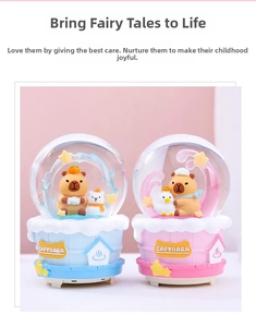 Close-up of pink and blue capybara snow globes featuring cute winter spa scene decorations