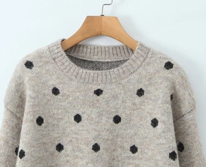 Dettaglio del girocollo a costine e della morbida trama a maglia del maglione a pois