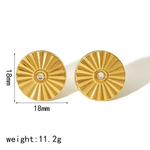 Detail of 18mm gold titanium earrings with radial texture and center gemstone