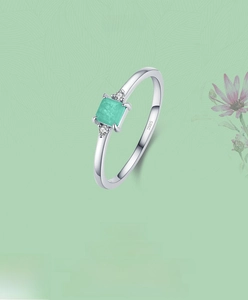 Macro detail of S925 silver ring featuring a square green gemstone and side stones