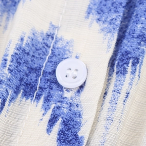 Close-up of a blue tie-dye printed dress showing the fabric texture and button detail