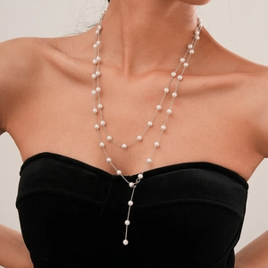 Detail of a silver double-layer pearl necklace on a model with minimalist draped design