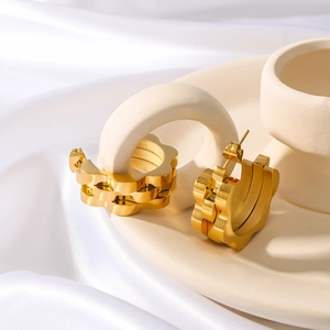 18k gold plated stainless steel hoop earrings with watchband pattern on a ceramic tray