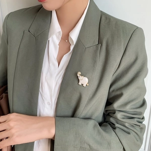 Cute enamel elephant brooch with sparkling crystals pinned on a green blazer lapel