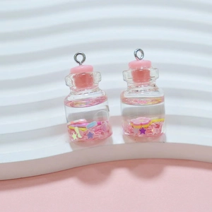 Detailed close-up of miniature glass bottle pendants with glitter and pink caps