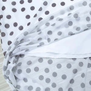 Detail of white mesh polka dot fabric with grey spots and inner lining texture