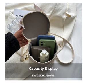Detail showing inner capacity of the beige cylindrical bucket bag with zipper opening
