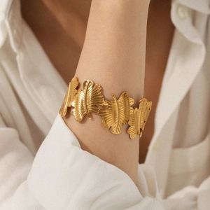 Makro-Detail der 18K vergoldeten Blattstruktur auf dem Edelstahl-Manschettenarmband