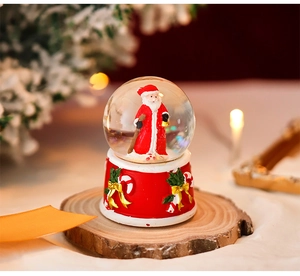 Detail of Christmas crystal globe music box with Santa figure on a rustic wood base