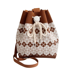 Brown and white checkered knit bucket bag with drawstring closure and woven strap