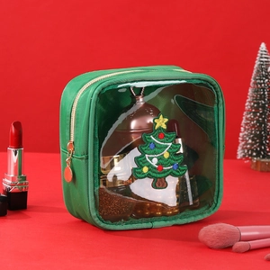 Detail of green makeup bag featuring a Christmas tree embroidery and clear window