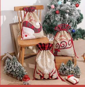 Close-up of linen Christmas drawstring bags with reindeer and Santa embroidery