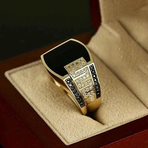 Macro shot of a luxury men's gold ring with square black gemstone and pavé diamonds
