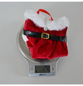 Detailed view of red Christmas wine bottle cover weighing 27.2g on a scale