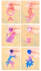 Close-up of DIY resin Christmas earrings with glitter and colorful gradient patterns