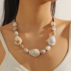 Detail of vintage handmade pearl and turquoise beaded necklace on neck with shell accents