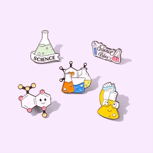 Set of five colorful science enamel pins with flasks and beakers on purple background