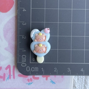 Macro detail of blue resin bear popsicle DIY charm showing dimensions on a ruler