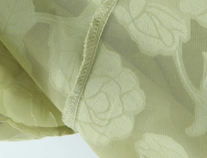 Detailaufnahme des grasgrünen Rosen-Jacquard-Stoffs und der sauberen Kantenverarbeitung
