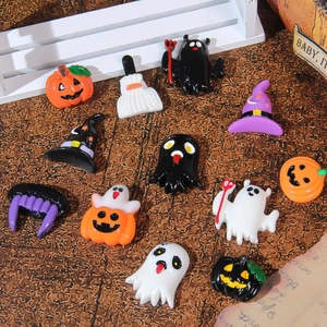 Flat lay of resin Halloween charms including pumpkins, ghosts, and bats on wooden background