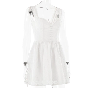 Close-up of intricate hollow lace patterns and decorative buttons on white dress