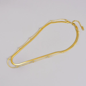Macro shot of double-layer gold snake chain and beaded link with K18 stamp detail