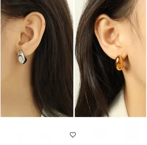 Detail of chunky 18K stainless steel hollow hoop earrings in gold and silver mirror finish
