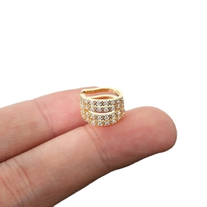Four-layer gold ear cuff with sparkling zircon crystals shown on finger for size