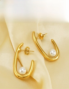 Détail de boucles d'oreilles en U plaquées or 18 carats avec perles sur soie